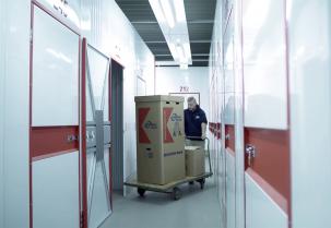 confern employee stows clothes box in storage room